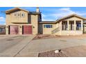 Two-story house showcasing a dual-car garage, desert landscaping, and a paved driveway at 260 E Desert Rose Dr, Henderson, NV 89015