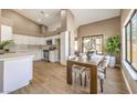 Eat-in kitchen with white cabinets, wood dining table, and sliding door to backyard at 6316 W Gowan Rd, Las Vegas, NV 89108