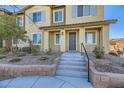 Tan two-story townhome with gray shutters and landscaping at 965 Nevada State Dr # 1101, Henderson, NV 89002