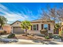 Single-story home with a two-car garage and palm trees at 4129 Cackling Goose Dr, North Las Vegas, NV 89084