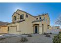 Two-story house with tan exterior, two-car garage, and desert landscaping at 6547 Velvet Silk St, North Las Vegas, NV 89084