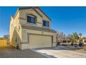 Tan two-story house with a two-car garage and desert landscaping at 6547 Velvet Silk St, North Las Vegas, NV 89084