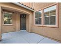 Home entrance with porch featuring a dark-colored front door and several windows at 6616 Sea Swallow St, North Las Vegas, NV 89084