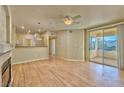 Spacious living room with fireplace, wood floors, ceiling fan, and sliding glass doors to a balcony at 7151 S Durango Dr # 214, Las Vegas, NV 89113