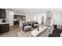Open-concept living room boasts wood-look flooring, modern furnishings, and seamless flow into the kitchen area at 647 N Water St, Henderson, NV 89015