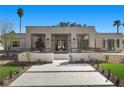 A modern home featuring a front yard, manicured trees, and a paver driveway at 2401 Driftwood Dr, Las Vegas, NV 89107