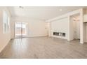 Bright living room featuring wood-look tile floors and modern fireplace at 106 Barkset Way, Henderson, NV 89011