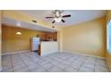 Open-concept living room with tile flooring, neutral walls, and a ceiling fan with view to the kitchen at 2020 Rancho Lake Drive Dr # 205, Las Vegas, NV 89108