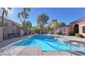 Community pool surrounded by a fence and lush greenery on a sunny day at 2020 Rancho Lake Drive Dr # 205, Las Vegas, NV 89108