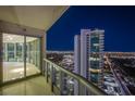 Balcony view overlooking the illuminated Las Vegas skyline at night with sliding glass doors at 222 Karen Ave # 3907, Las Vegas, NV 89109