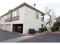 Two-story condo with an attached garage, neutral stucco, a red truck inside the garage and well-kept grounds at 6808 Indian Chief Dr # 204, Las Vegas, NV 89130