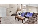 Bright living room featuring a sectional sofa and a staircase at 7741 Falconwing Ave, Las Vegas, NV 89131