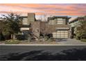 Modern home exterior at sunset, showcasing stone and glass at 5 Moonfire Dr, Las Vegas, NV 89135