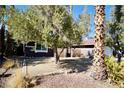 Landscaped front yard with mature trees and a brick wall at 7393 Puritan Ave, Las Vegas, NV 89123