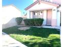 This cozy home features a manicured front lawn with shrubs at 319 Fox Lake Ave, Las Vegas, NV 89148