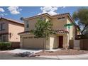 Tan two-story house with red door and attached garage at 3367 Villa Fiori Ave, Las Vegas, NV 89141