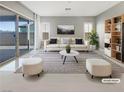 Bright living room with stylish furniture, a striped rug, and sliding glass doors for natural light at 3408 Isle Dr, Las Vegas, NV 89141