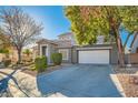 Two-story house with gray siding, white garage door, and landscaping at 6019 Orca Lilly St, North Las Vegas, NV 89031