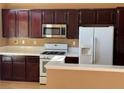 Modern kitchen features dark wood cabinets, stainless steel appliances, and ample counter space at 1531 Singing Bird Ln, North Las Vegas, NV 89031