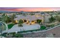 Expansive home with a circular driveway, porte cochere, mature trees, and landscaping at 2870 Quartz Canyon Dr, Henderson, NV 89052