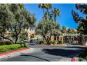 Gated entrance to a community with mature trees, manicured landscaping and controlled access at 230 E Flamingo Rd # 212, Las Vegas, NV 89169