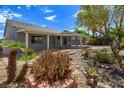 Landscaped backyard featuring a covered patio and well-maintained desert landscaping elements at 3591 Driving Range St, Las Vegas, NV 89122