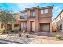 Charming two-story home with stucco exterior, small balconies, desert landscaping and brick driveway at 177 Almond Ridge Pl, Henderson, NV 89015