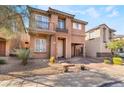 Charming two-story home with stucco exterior, small balconies, desert landscaping and brick driveway at 177 Almond Ridge Pl, Henderson, NV 89015