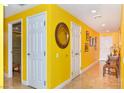 Hallway with yellow walls has tile flooring, multiple doors, and a round mirror on the wall at 200 W Sahara Ave # 601, Las Vegas, NV 89102