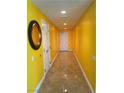 Long hallway with recessed lighting, tile flooring, and bright yellow walls leads to the front door at 200 W Sahara Ave # 601, Las Vegas, NV 89102