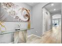 Bright foyer featuring light wood floors, modern art, and a stylish glass console table at 2391 Dalewood Ave, North Las Vegas, NV 89086
