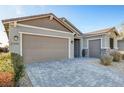 Stylish single-story home featuring a three-car garage, desert landscaping, and a modern driveway at 2391 Dalewood Ave, North Las Vegas, NV 89086