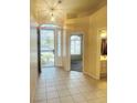 Inviting foyer featuring tile floors, security screen door, and a decorative hanging light fixture at 5048 Orchid Springs St, Las Vegas, NV 89148