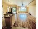 Bright living room with hardwood floors, large windows, and a breakfast bar overlooking the kitchen at 5048 Orchid Springs St, Las Vegas, NV 89148