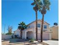 Two-story house with a pink garage door and two palm trees in front at 5402 Night Swim Ln, Las Vegas, NV 89113