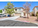 Two-story house with beige exterior, attached garage, and landscaping at 10168 Maidens Wreath Ct, Las Vegas, NV 89183