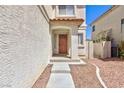 Front entry with orange door and concrete steps leading to the entrance at 10168 Maidens Wreath Ct, Las Vegas, NV 89183