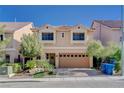 Tan two-story house with a two-car garage and nicely landscaped front yard at 5957 Pillar Rock Ave, Las Vegas, NV 89139