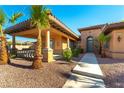 Front entrance with covered porch, stone accents, and lush landscaping at 5024 Crown Cypress St, Las Vegas, NV 89149