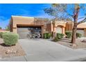 Tan one-story house with a brown door and two-car garage at 9452 Gold Mountain Dr, Las Vegas, NV 89134