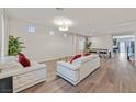 Open living room with white leather couches and large windows at 9753 Russian Hill St, Las Vegas, NV 89141