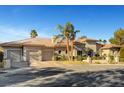 Daytime view of home's exterior showcasing a tile roof, multiple garages, and manicured landscaping at 2111 Bogart Ct, Las Vegas, NV 89117