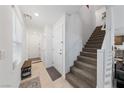 Bright and airy entryway with staircase, tile flooring and bench at 318 Brockbank Pl, Henderson, NV 89011