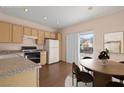 Virtually staged kitchen with light wood cabinets and dining area at 2185 Indigo Creek Ave, Henderson, NV 89012