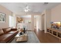 Virtually staged living room with brown leather couch and wood floors at 2185 Indigo Creek Ave, Henderson, NV 89012