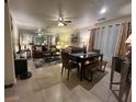 Cozy living room with tile flooring, a ceiling fan, dining table, and a mirrored wall feature at 6216 Pangea Ave, Las Vegas, NV 89139
