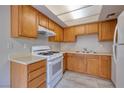 Galley kitchen with wood cabinets and white appliances at 4338 Caliente St # 4, Las Vegas, NV 89119