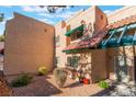 Tan stucco townhouse with green accents and desert landscaping at 6750 Del Rey Ave # 122, Las Vegas, NV 89146