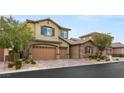 Two story house with tan siding, brown garage doors and stone accents at 7563 Saguaro Cactus Ave, Las Vegas, NV 89178