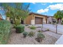 Landscaped front yard with stone pathway leading to three car garage at 1313 Alamosa Ridge Ct, North Las Vegas, NV 89084